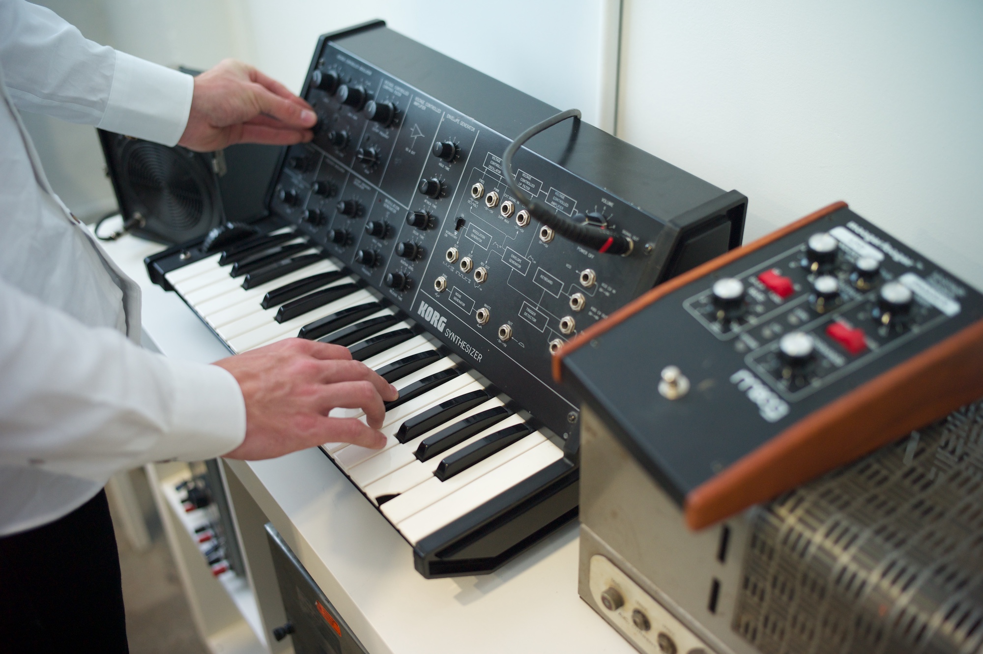 Close-up of hands playing a synthesizer keyboard during a music composition session